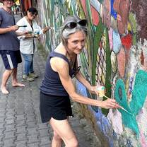 Spanish immersion student painting a colorful mural in a Pueblo Mágico town in Mexico