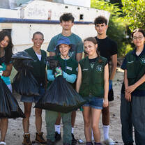A team of volunteers smiling together after collecting waste on a beach