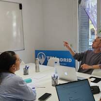 Participants discuss a lesson around laptops in a TEFL Madrid classroom.