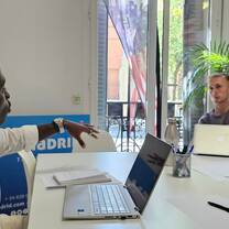 Two participants work with a laptop and notes in the Madrid classroom.