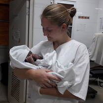 Holding a baby at the hospital in Ghana