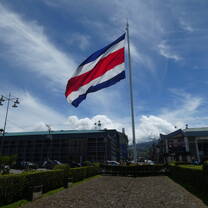 Large flag of Costa Rica in a city plaza.