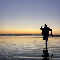 Running along beautiful Waitarere Beach at sunset