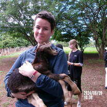 A picture of me and a baby goat on the farm