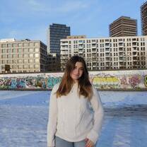 Ainsley Braun standing in front of the East Side Gallery in Berlin, Germany, February 2025 