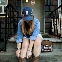 Ainsley Braun in an IES Abroad hat showcasing a pin collection, July 2025
