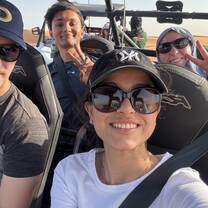 Exchange students riding a dune buggy through the desert in the UAE.