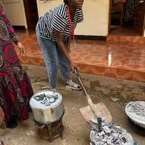 Students preparing charcoal fire to bake cake.