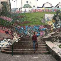 Colorful staircase in Ecuador winding up a hillside, surrounded by vibrant buildings and lush greenery.
