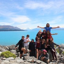group of people standing on rocks in front of ocean