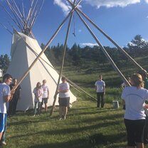 Helping to build tipis with community members.