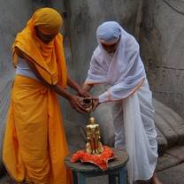 Two women holding hands over a gold statue