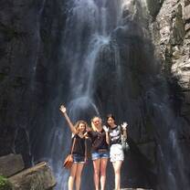Au pairs are in front of waterfall
