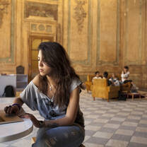 girl on computer in large room