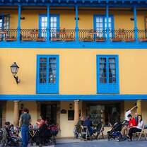 People sit outside of a brightly colored cafe in Oviedo.