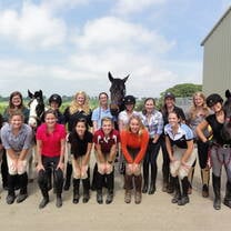 Group of international students posing with horses in a Scottish farm as part of the summer equine program.