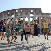 students jumping in front of colosseum