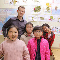 South Korea offers some of the best benefits out of all teach abroad programs English teacher in South Korea with young students