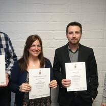 Three Trinity Cert. course participants getting their certificates