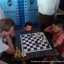 Volunteers playing chess with local children