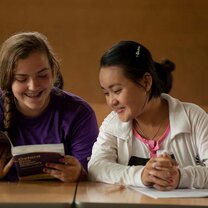 two girls studying one is holding book