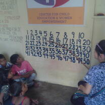 Volunteers teaching counting to kids in Center