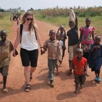 A volunteer holding hands with children