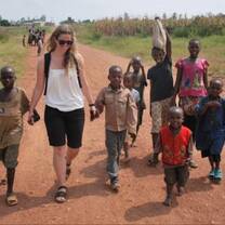 A volunteer holding hands with children