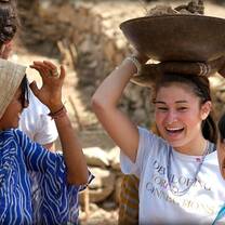 Young woman with locals balancing bowl on her head
