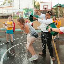 Volunteer plays with children on sports ground, Russia, Jun 2013