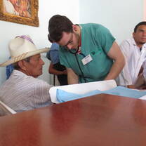 A volunteer taking a patient's blood pressure