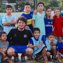international volunteer together with many children from the sports program smiling to the camera
