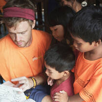 Volunteer teacher with children picking out colouring-in pages