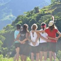 Group of volunteers hiking and hugging in mountain scenery