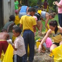 Volunteers work with children in their neighborhood clean up.