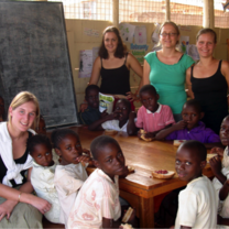Volunteers with children in a classroom in Uganda